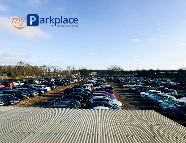 Parkovisko myParkplace – Početné autá zaparkované na priestrannom území. Parkovisko je vonku, bez viditeľného oplotenia. Vedľa sú stromy.