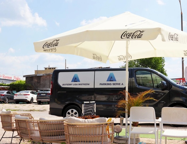 Najlepšia parkovacia séria A – Pod slávou stojí čierny autobus. Na pozadí sú viditeľné zaparkované autá.