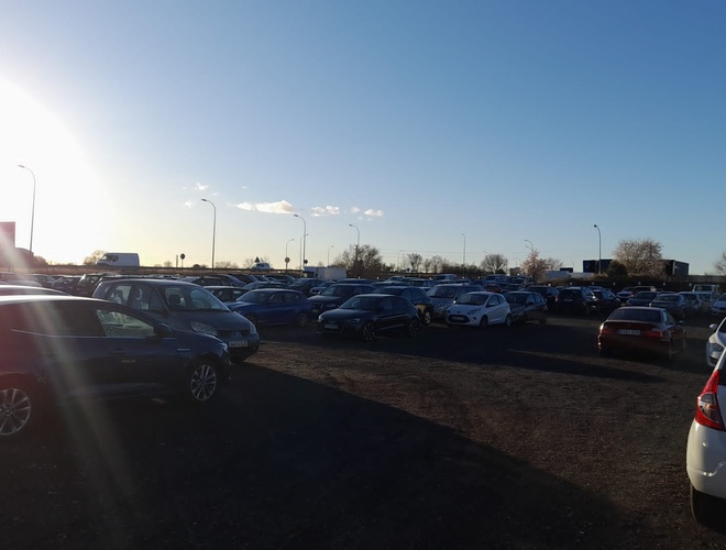 Parking Pleyades Valet - El lugar está lleno de coches. El sol ilumina el área. Alrededor crecen algunos árboles.
