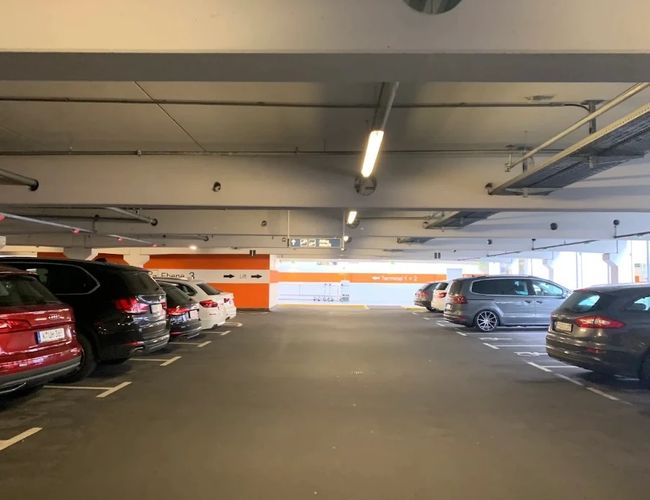 Poziom parkingu wielopoziomowego z miejscami postojowymi i samochodami.