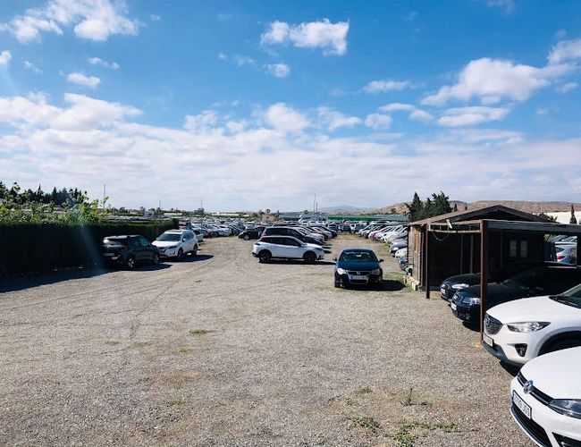 Sunline Parking Outdoor Valet - Na otwartym terenie stoją samochody. Parking jest żwirowy i nieogrodzony. Obok stoi niewielki drewniany budynek.