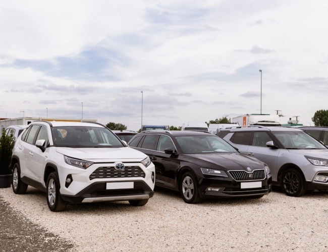 Coches estacionados en una superficie pavimentada del parking. Parking exterior.