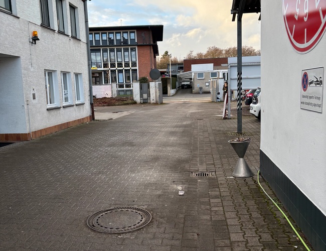 Parkering ParkPoint24 Verktøy - Gjerde sikret med lås. En ledig plass er synlig i bakgrunnen. Atmosfæren er rolig og ordnet.