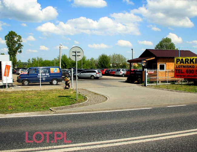 Parkovisko P38 - Priestor je ohradený a osvetlený. Sú viditeľné zaparkované autá a búdka pri vstupe.