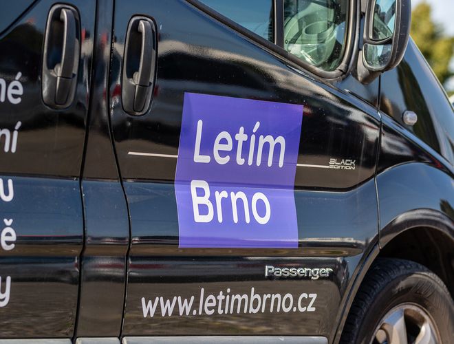 Parcarea Letim Brno – latura vizibilă a unei mașini negre cu inscripția Letim Brno. Pe uși, un logo mare de culoare mov.