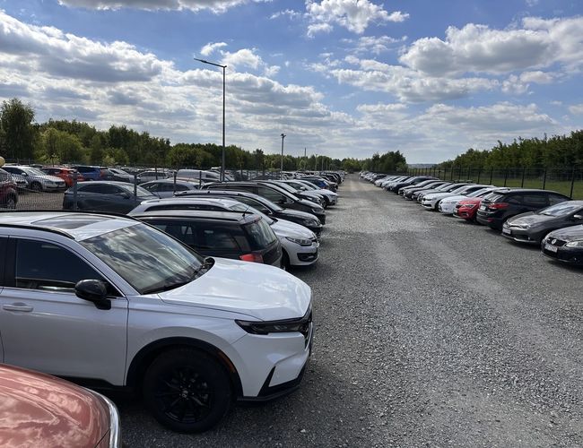 Plac parkingowy z utwardzoną nawierzchnią i zaparkowanymi samochodami