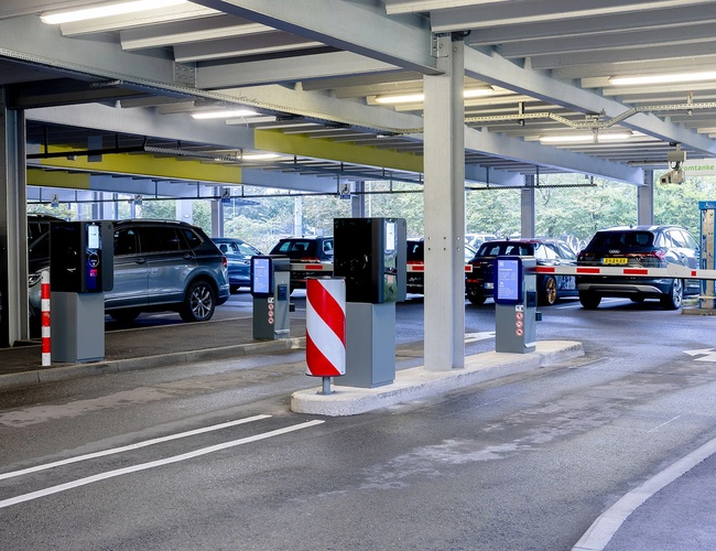 Zadaszony wjazd do parkingu P5 z oznakowaniem kierunkowym oraz pasami ruchu prowadzącymi do miejsc postojowych.