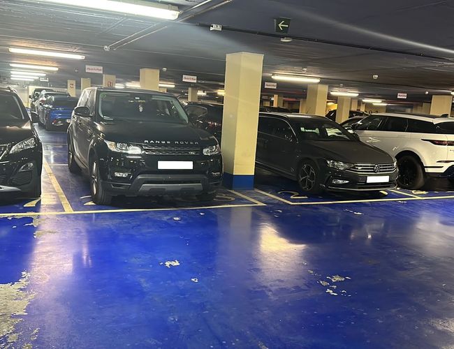 Parcare Mașini și Zbor Garaj Viteză - Interiorul parcării subterane. Mașinile sunt parcate în locuri echitabil semnalizate. Zona este bine iluminată.