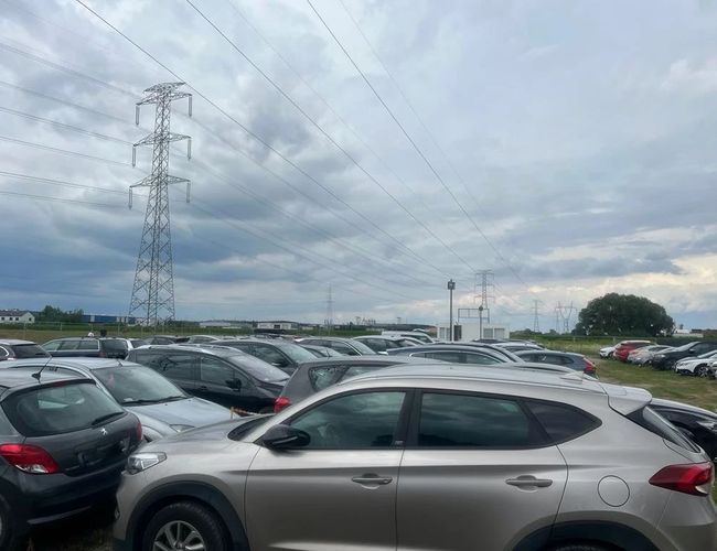 Widok samochodów zaparkowanych na terenie parkingu.