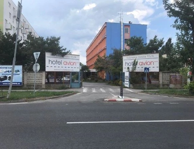 Parking Letisko Parkovisko  – Widoczny wjazd na parking ze znakami i nazwą parkingu. Perspektywa od strony ulicy.