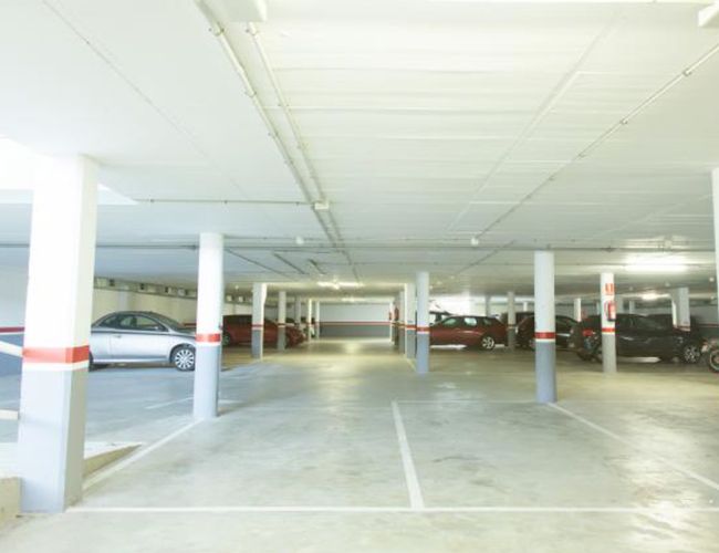 WeParking Valet – Podziemny parking z kolumnami i oświetleniem. Samochody stoją w rzędach, przestrzeń jest uporządkowana.