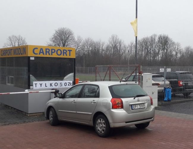 Parkplatz Carport – Die Autos sind neben dem Parkhäuschen geparkt. Das Gelände ist umzäunt und befindet sich im offenen Bereich.