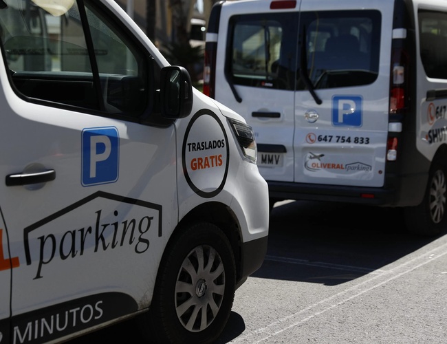 Oliveral Parking – Dwa białe busy z logo. Jeden bus z przodu, drugi z tyłu. Po bokach napisy o darmowym transferze.