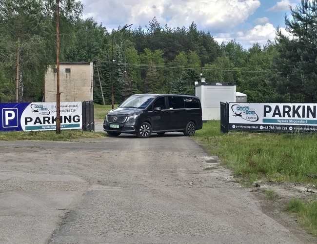 Plac parkingowy z utwardzoną nawierzchnią i zaparkowanymi samochodami