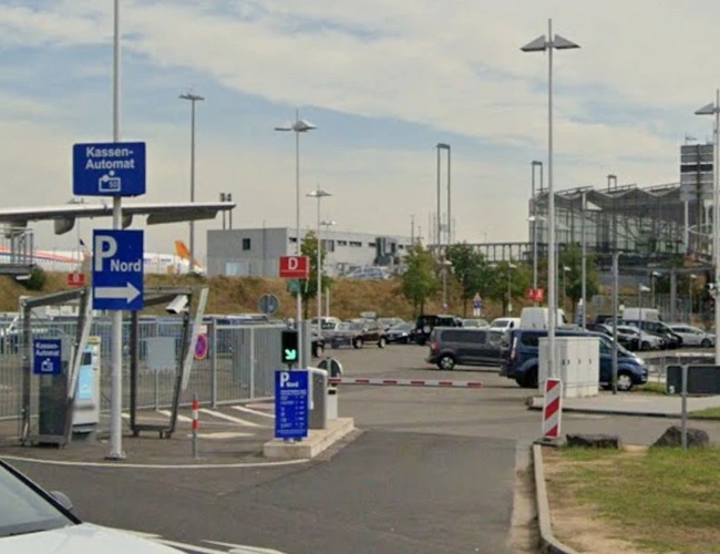 Wjazd do oficjalnego parkingu NORD na lotnisku Cologne Bonn z czytelnym oznakowaniem, szlabanami oraz wygodnym dojazdem do terminali pasażerskich.