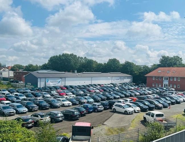 Servicio de estacionamiento Parkservice Bremen. Gran área llena de coches particulares aparcados, visible en un día soleado.