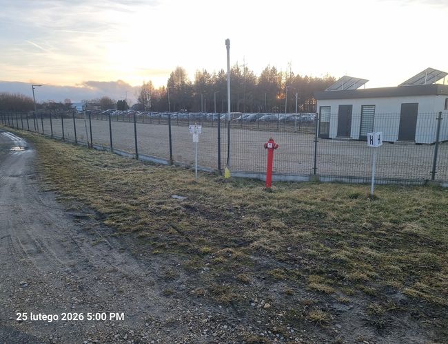 Plac parkingowy z utwardzoną nawierzchnią i zaparkowanymi samochodami