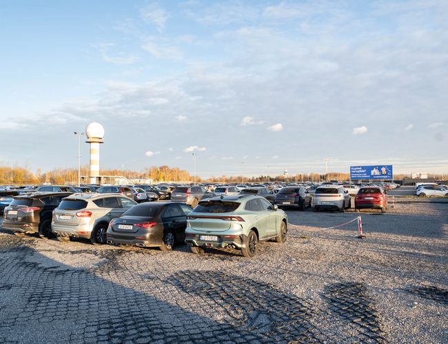 Easy Parking Express – Parking ogrodzony, wyłożony żwirem. Parkuje tu wiele samochodów osobowych. Lampy uliczne zapewniają oświetlenie po zmroku.