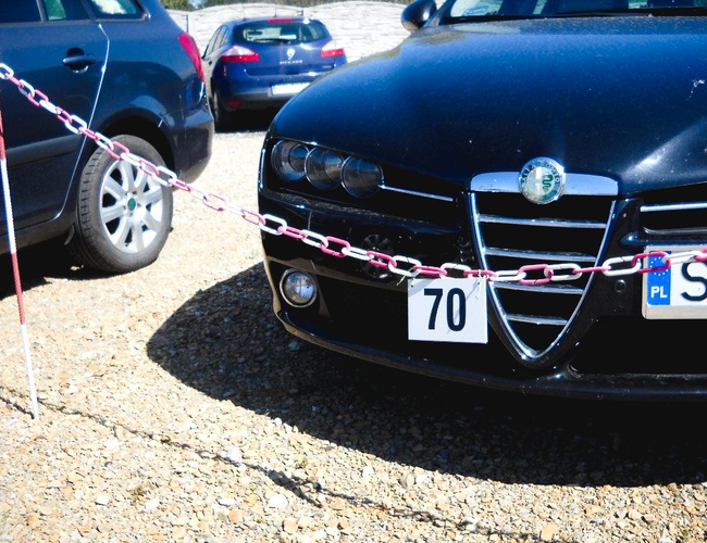 VIAJAR – En el aparcamiento hay tres coches. Una cadena separa el lugar. El terreno es de grava.