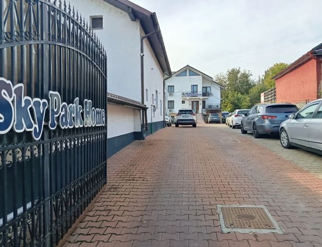 Wjazd na parking Sky Park w pobliżu lotniska w Iași – widoczny szyld parkingu z informacjami kontaktowymi oraz oznaczenie parkingu przy ulicy.
