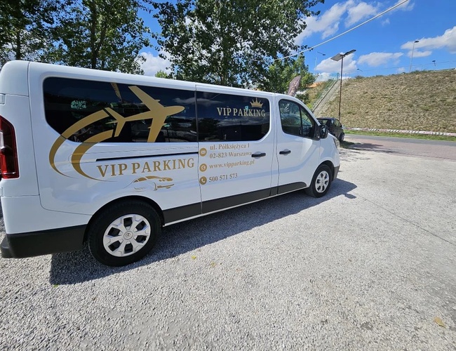 VIP Parkovanie - pri trati S2. Biela dodávka s logom firmy stojí na kamenistom dvore. Na pozadí sú stromy a osvetlenie.