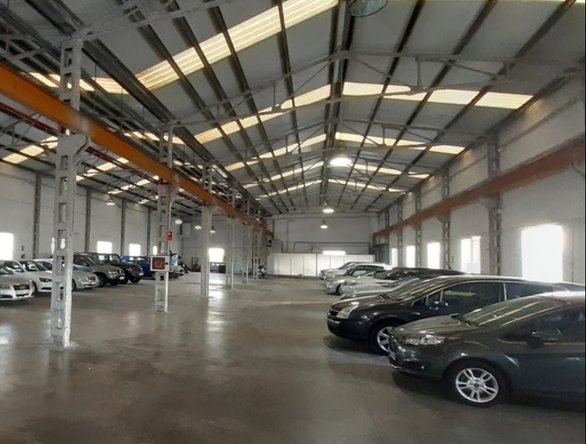 Victoria Parking Valencia - un amplio salón con coches aparcados. El terreno está cubierto y bien iluminado. El interior está ordenado y limpio.