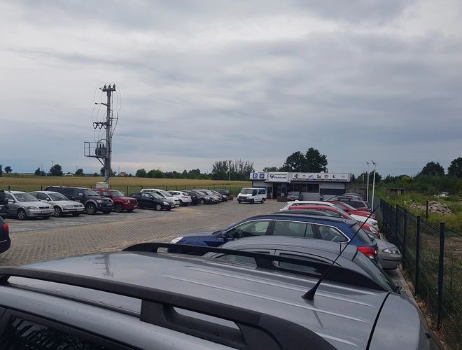 PARKING P24 PREMIUM - Nagyon nagy parkoló sok autóval. A terület kerített. Látható az infrastruktúra.