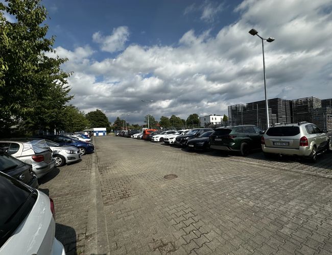 Ansicht der parkenden Autos auf einem Parkplatz, der vollständig mit Pflastersteinen ausgelegt ist.