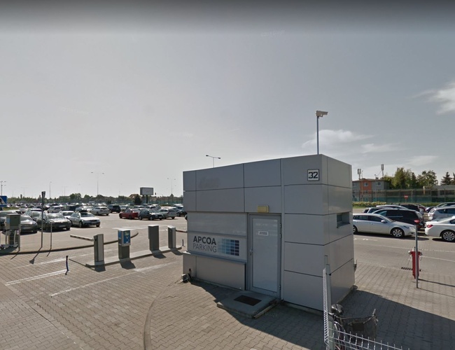 Oficiálne parkovisko P2 - Veľké oplotené parkovisko s strážnicou. Automobily stoja v radoch. Vedú k nemu jasné označenia.