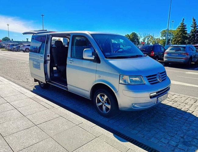 Parking MARTOM – Un coche plateado con las puertas abiertas está en el estacionamiento. En el fondo se pueden ver otros autos estacionados.