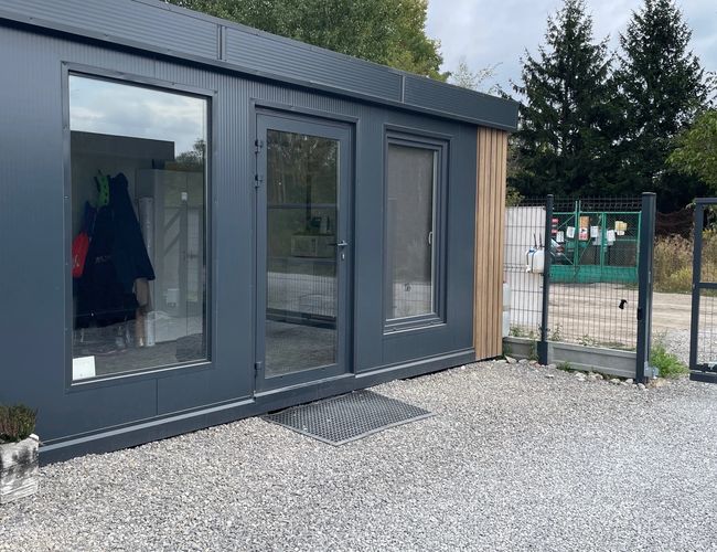 Parking Simple Park – Ogrodzony parking z szlabanem na wjeździe. Wzdłuż drogi stoją zaparkowane samochody.