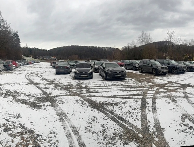 Victory Cars – żwirowy parking . Samochody zaparkowane na terenie parkingu. w tle widoczne są drzewa.