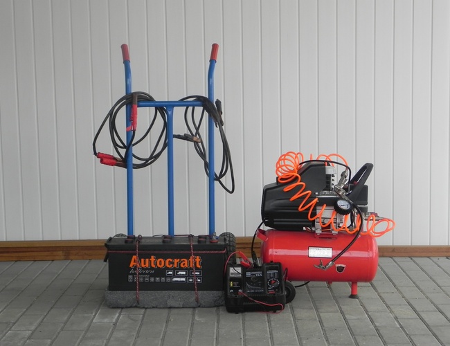 WIZ-PARK – Junto a la pared hay un carro y un compresor. En el suelo hay un cable.