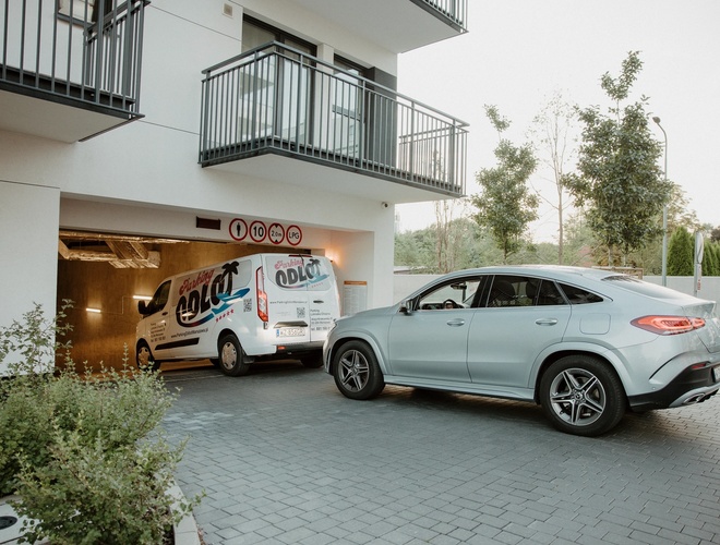 Odlot Garage - Podziemny parking z miejscami dla samochodów. Oświetlony i oznaczony żółto-czarnymi pasami.