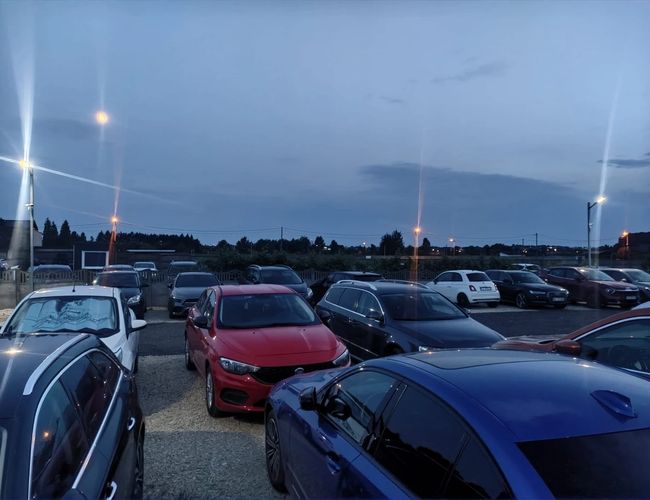 Plac parkingowy wraz z zaparkowanymi pojazdami z innej strony