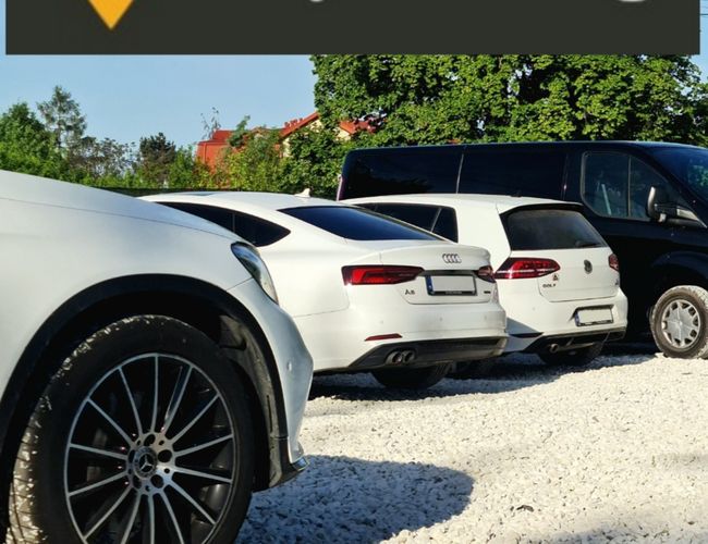 MyParking - Fahrzeuge stehen auf einem Kiesparkplatz. Das Gelände ist von Grün umgeben.