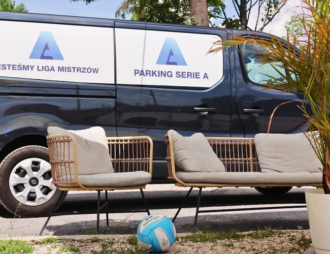 Najlepšia parkovacia séria A – dodávka stojí vedľa dvoch stoličiek. Je vidieť loptu, vedľa je krík v kvetináči.