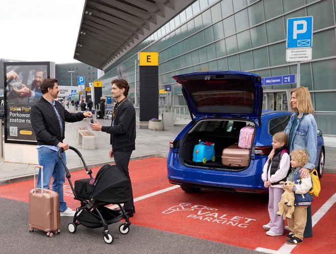 Valet Parking – Chopin-Flughafen – Der Fahrer im Auto spricht mit dem Parkwächter. Neben dem Schild mit dem Valet Parking-Logo. Oberfläche aus Gehwegplatten.