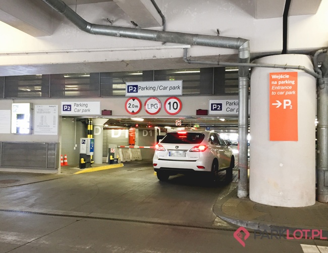 Oficiálne parkovisko letaiska P2 – Auto vchádza na kryté parkovisko. Je nízky maximálny výškový limit. Značka ukazuje smer k vstupu.