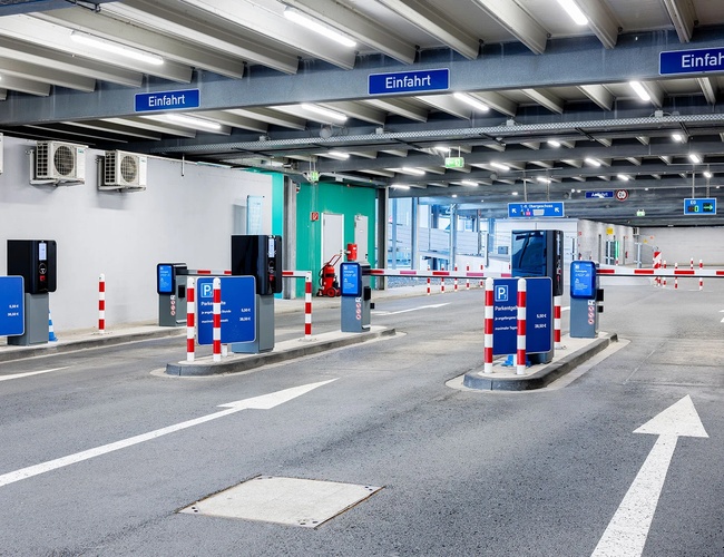 Wnętrze parkingu P7 z szerokimi pasami ruchu, szlabanami oraz systemem poboru opłat przy wjeździe.